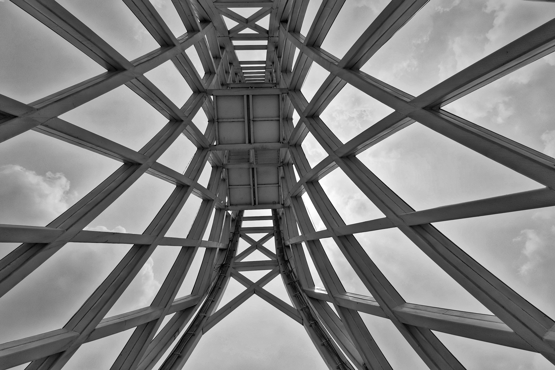 Intersecting steel members seen from below, forming a geometric structural framework
